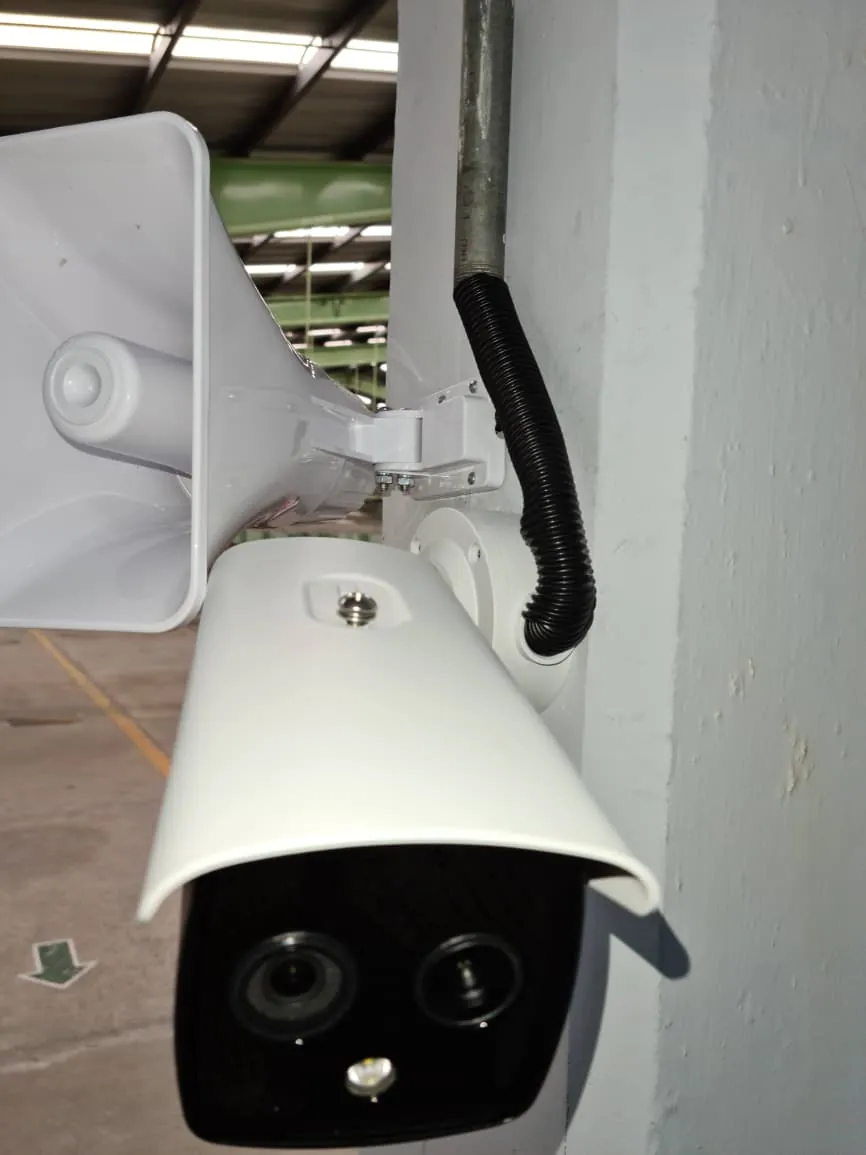 Cámara exterior junto a un altavoz instalada en una columna