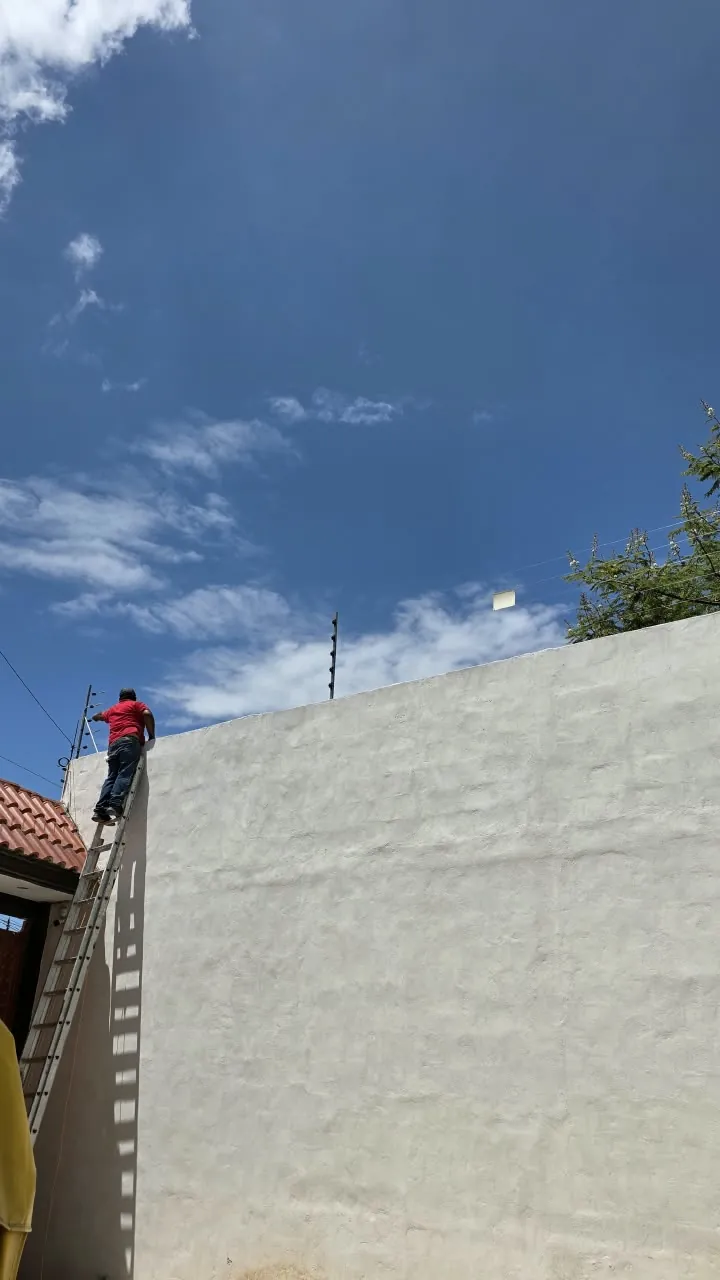 Trabajo de instalación de cerca eléctrica sobre una barda