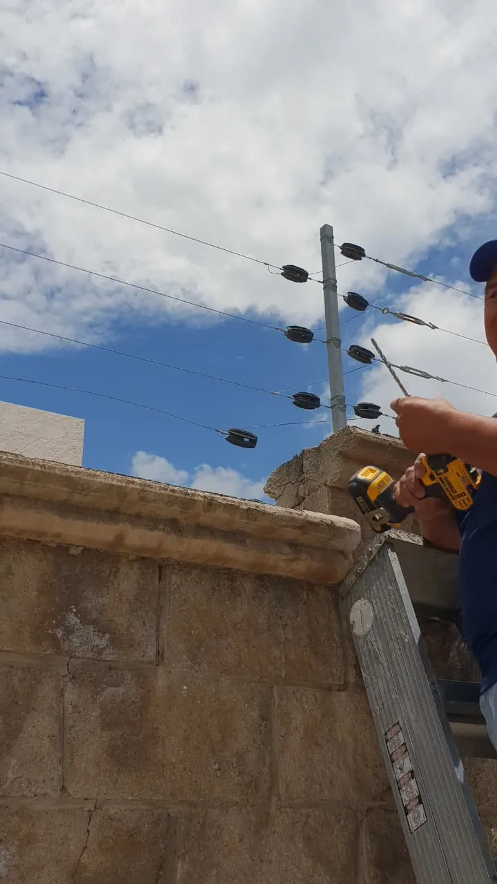 Instalación de postes y alambres de cerca eléctrica sobre una barda